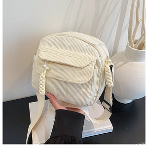 Détail du sac bandoulière en velours côtelé blanc avec poche à rabat et tirette tissée
