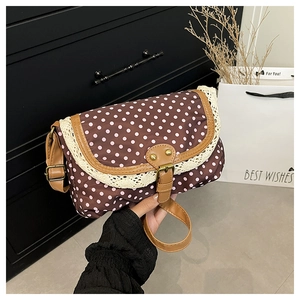 Detail of retro polka dot canvas bag with delicate lace trim and vintage metal buckle