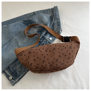 Detalle de riñonera de pana marrón con estampados de corazones sobre chaqueta vaquera