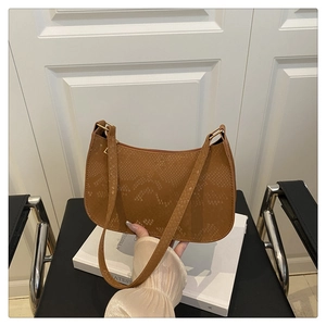 Detail shot of brown snakeskin texture and strap design on this trendy underarm shoulder bag
