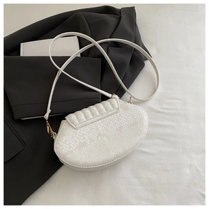 Macro detail of white faux snake leather handbag with gold buckle on black suit