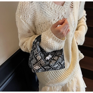 Détail du sac hobo avec motifs géométriques blancs et deux perles décoratives fines