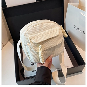 Vue détaillée du sac bandoulière en velours côtelé crème avec zip à nœud tressé