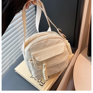 Détails du sac à bandoulière en velours côtelé blanc cassé avec pendentif à franges