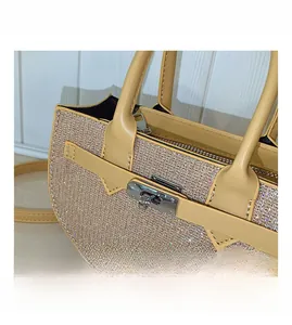 Detail of silver twist lock and sparkling rhinestones on ginger Kelly-style handbag
