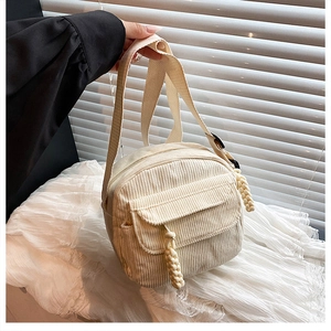 Détail d'un petit sac bandoulière en velours côtelé crème avec sangle tissée et rabat