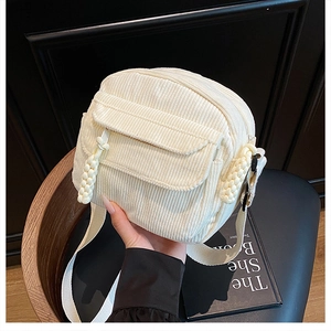 Détail du sac bandoulière en velours côtelé blanc avec garniture tressée et poche
