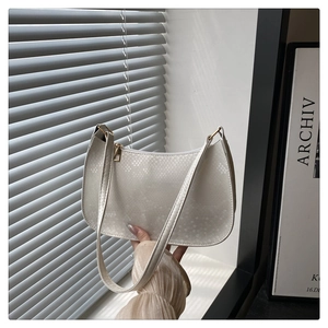 Close-up of white snake texture shoulder bag with gold zipper and minimalist decor