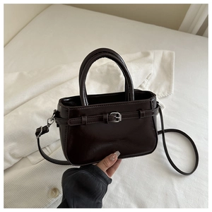 Vue détaillée du sac à main en similicuir marron foncé avec boucle argentée et bandoulière