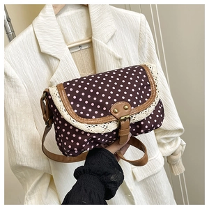 Close-up of retro polka dot canvas bag with lace trim and brown leather strap
