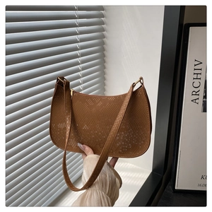 Close-up of brown faux snake skin texture and gold zipper on a chic hobo shoulder bag