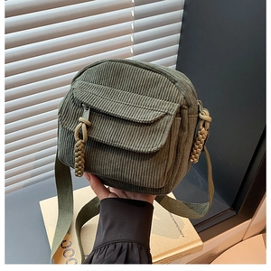 Gros plan détaillé du sac bandoulière en velours côtelé vert avec cordons tressés