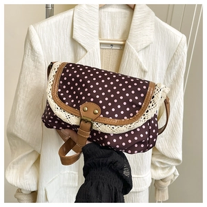 Detail shot of vintage polka dot canvas bag with lace trim and brown faux leather trim