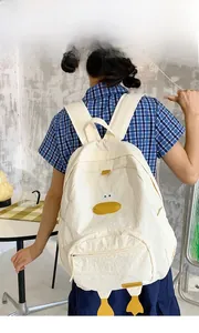 Detail of white cartoon duck backpack with 3D feet and embroidery on industrial background