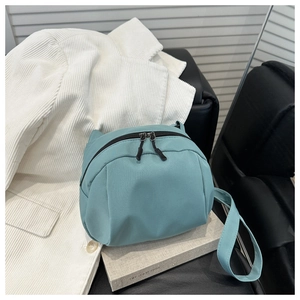 Detail of mint green cat-ear shoulder bag with dual zippers on corduroy fabric