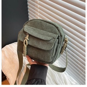 Détail de la texture du sac en velours côtelé vert foncé avec fermeture éclair