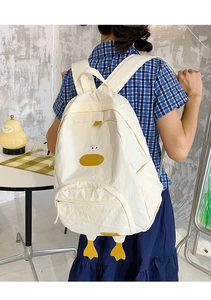 Detailed close-up of cute cartoon duck design on beige nylon backpack with 3D duck feet