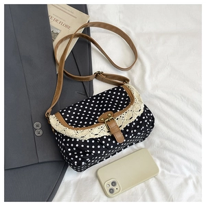 Detailed view of polka dot canvas bag featuring lace trim and vintage brown PU strap