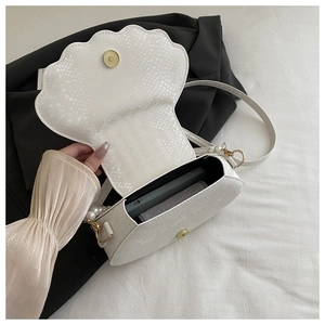 Detail of white shell bag with snake texture, pearl charms and gold Paris magnetic buckle