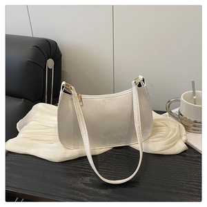 Detailed view of white snakeskin texture underarm bag with gold zipper on silk