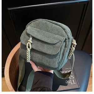 Détail du sac bandoulière en velours côtelé vert sauge avec fermeture tissée