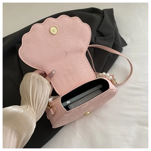 Pink shell handbag with pearl strap and textured leather showing interior capacity