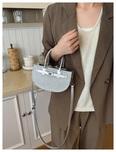 Close-up of silver sequin saddle bag featuring metallic hardware and buckle details