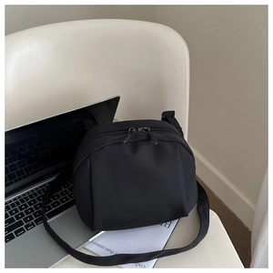 Vue détaillée du sac bandoulière croissant en nylon noir avec double fermeture