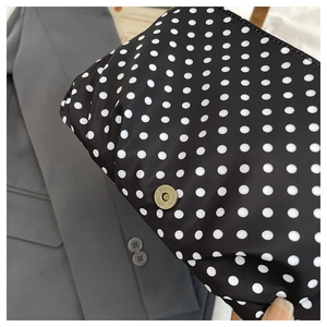 Detail of retro polka dot canvas bag featuring a bronze magnetic buckle closure