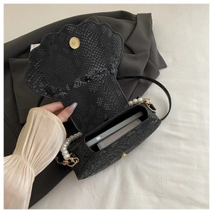 Interior view of black shell bag with snake texture showing space for a smartphone
