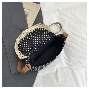 Close-up of black polka dot canvas bag interior with lace trim and brown strap detail