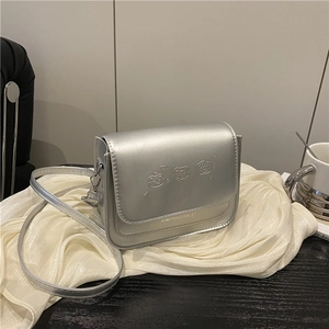 Sac bandoulière argenté chic avec gaufrage ours sur un élégant fond en tissu blanc
