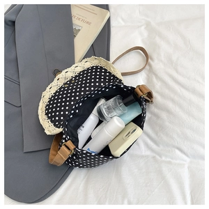 Spacious interior of black polka dot crossbody bag with lace trim and leather strap
