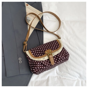 Close-up of retro polka dot canvas bag with white lace trim and leather buckle