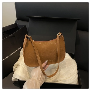 Detailed close-up of brown snakeskin texture bag with golden zipper on silk background