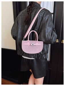 Detailed view of pink glitter saddle bag with silver clasp shown on a model's back