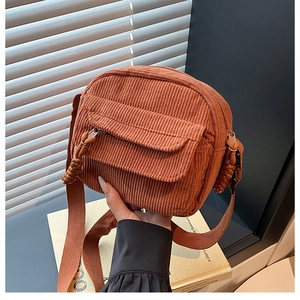 Détail du mini sac bandoulière en velours côtelé rouille avec poche à rabat et zip en corde