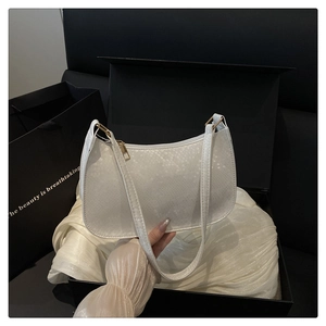 Close-up of white snakeskin texture on luxury shoulder bag with gold zipper and satin lining