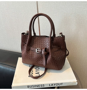 Close-up of coffee brown woven leather tote with intricate Intrecciato texture and buckle