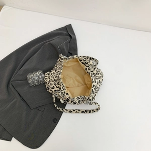 Leopard print corduroy tote bag with pearl accessory on a grey blazer suit