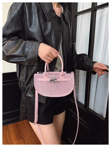 Pink sequin crescent handbag with silver metal turn-lock detail on sleek black leather