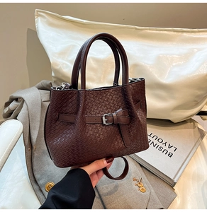Dettaglio della borsa intrecciata marrone scuro con fibbia decorativa in stile business