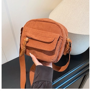 Détail du petit sac bandoulière en velours côtelé caramel et tirette de zip tressée
