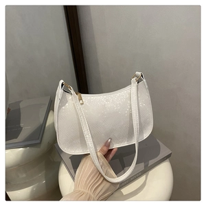 Close-up of white hobo bag featuring snake pattern texture and gold zipper detail