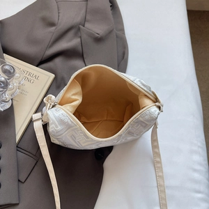 White dumpling bag with geometric embroidery and interior storage shown from above