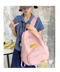 Detailed view of pink cartoon duck backpack with orange fins and fashion logo label