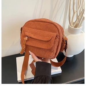 Détail d'un sac bandoulière en velours côtelé marron avec sangle réglable et texture