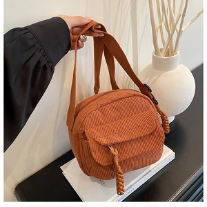 Détail de la sacoche en velours côtelé caramel avec poche à boucle et tirettes en corde tressée