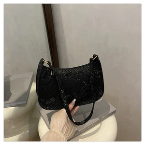 Close-up of black faux snakeskin shoulder bag with textured scale finish and sleek zipper