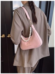 Detail of light pink leather shoulder bag with elegant pearl chain and branding